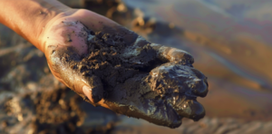 Bohrschlamm entsorgen Hand mit Schlamm